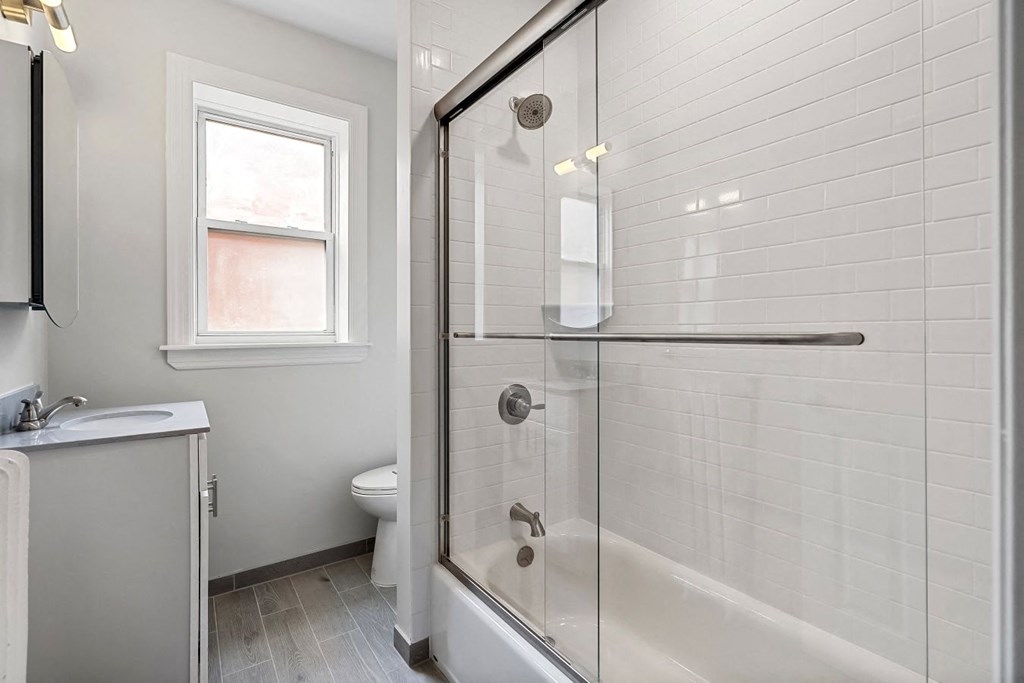 a bathroom with a shower and a sink and a toilet