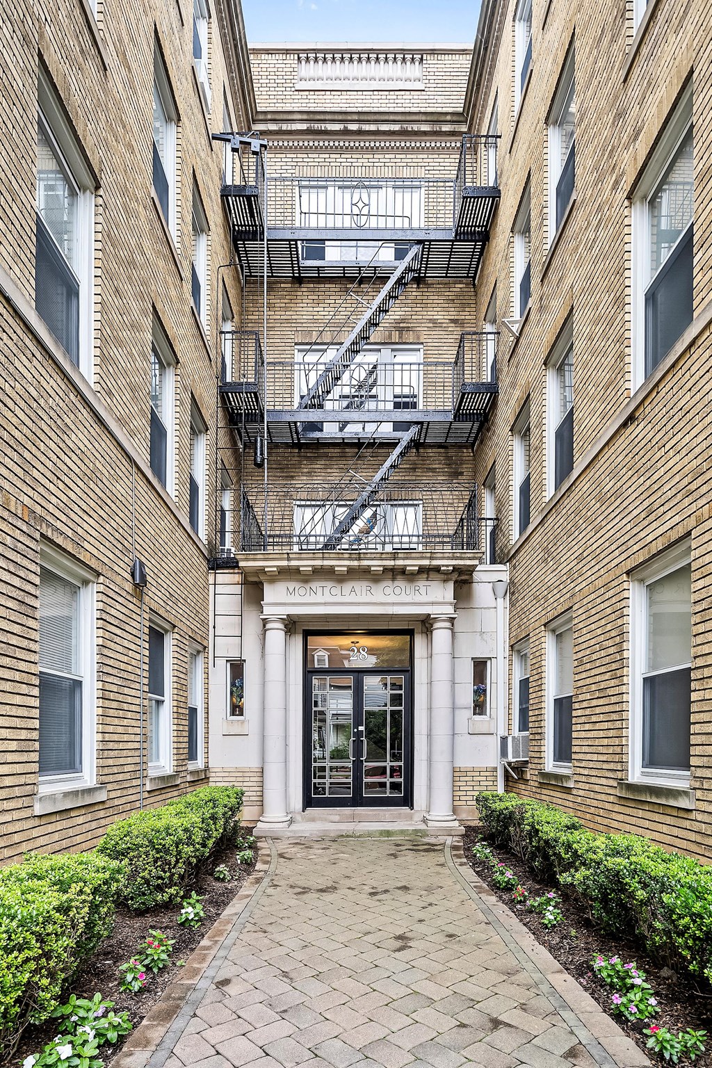 the entrance to an apartment building with a walkway and a fire escape