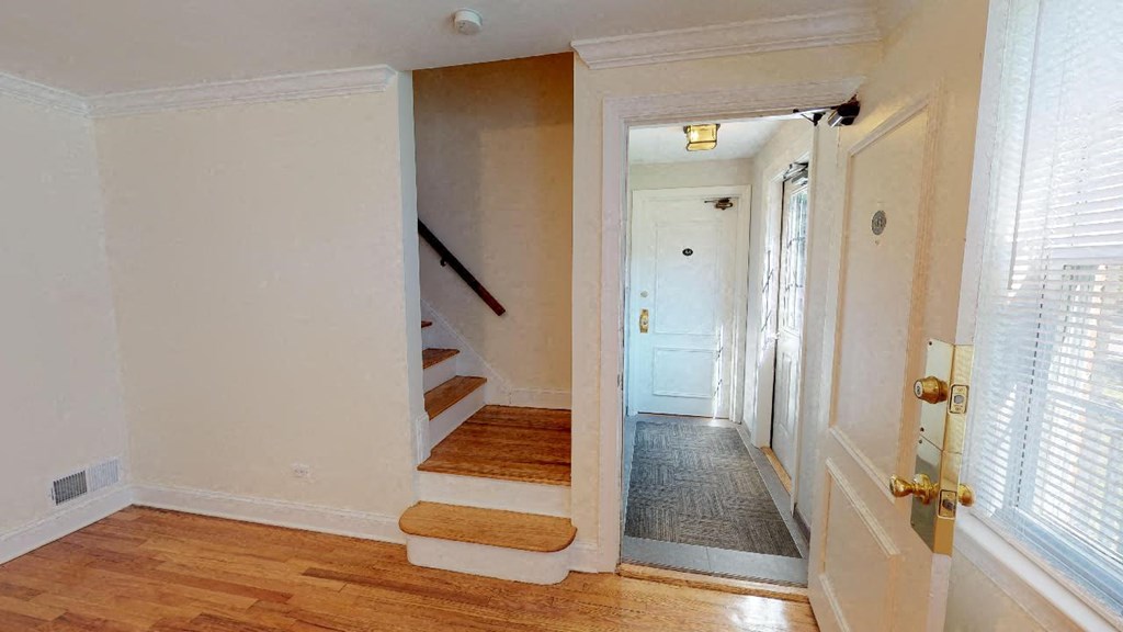 a hallway with a staircase and a door to a room