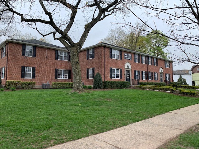 a brick building with a lawn in front of it