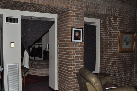 a living room with a couch and a brick wall