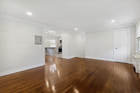 a living room with a hard wood floor and white walls