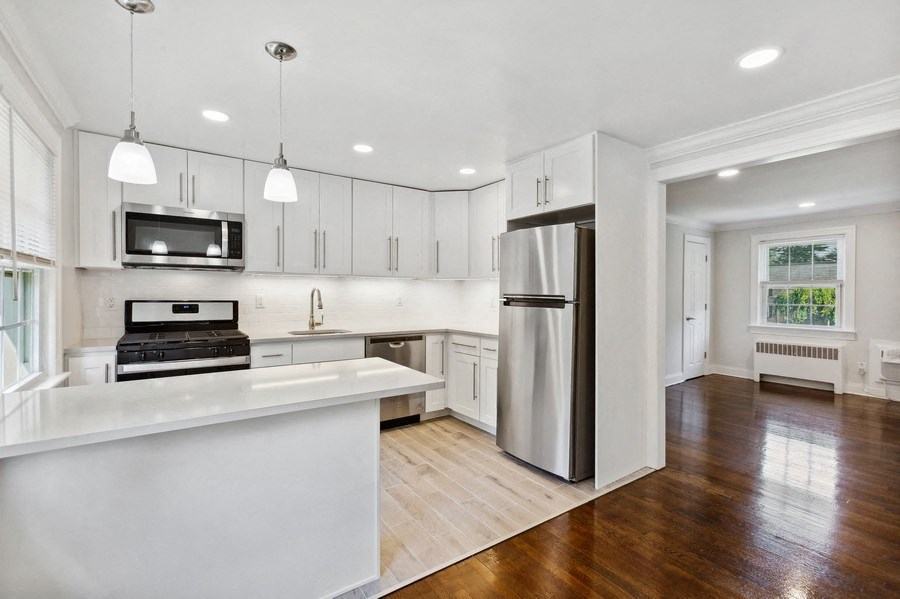 a kitchen with white cabinets and a stainless steel refrigerator