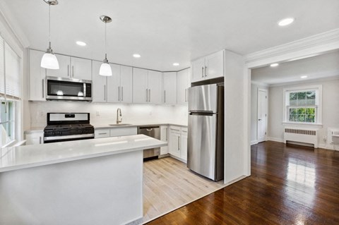 a kitchen with white cabinets and a stainless steel refrigerator
