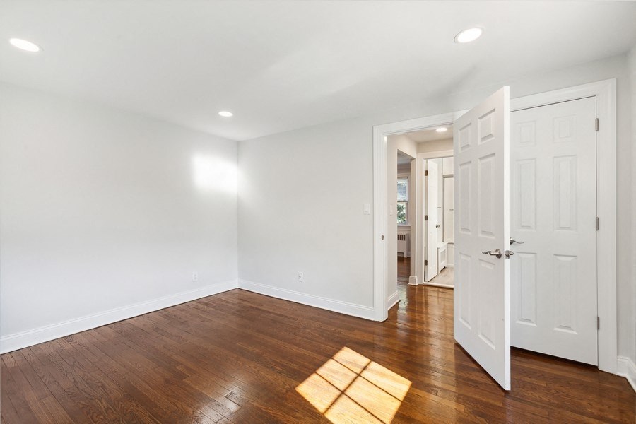 an empty living room with white walls and wood floors