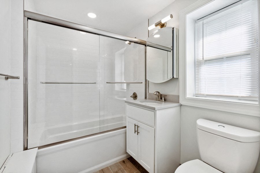 a bathroom with a shower and a sink and a toilet