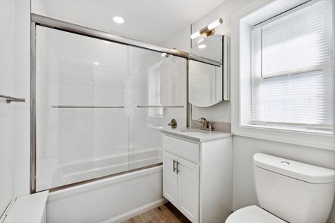a bathroom with a shower and a sink and a toilet