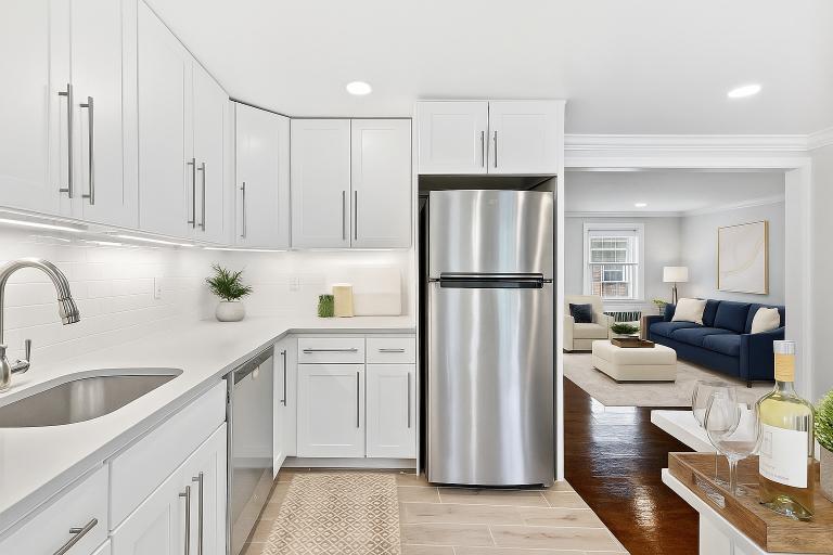 A modern kitchen with a stainless steel refrigerator and white cabinets.
