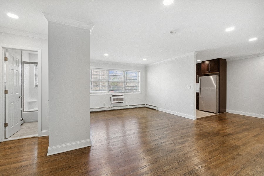an empty living room with white walls and wood floors