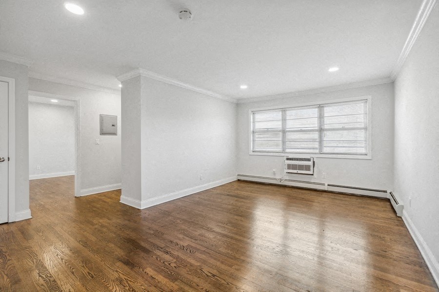 an empty living room with white walls and wood floors