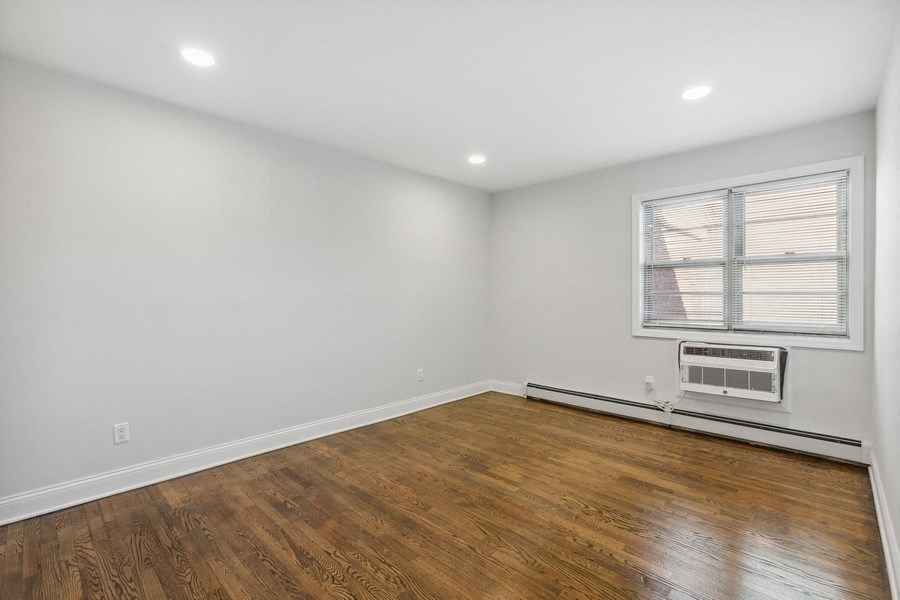 an empty living room with wood flooring and a window