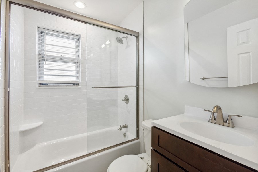 a bathroom with a shower and a sink and a toilet