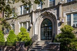 the front of a building with a door and stairs