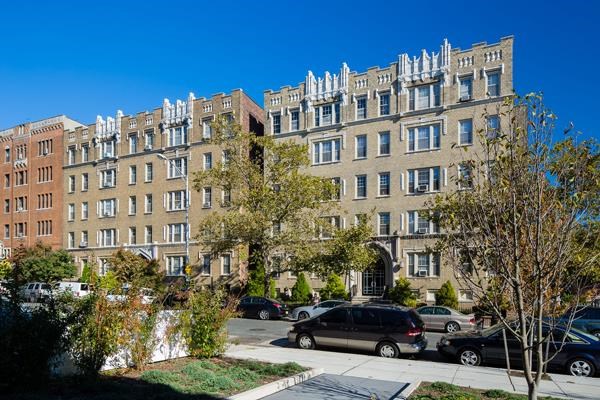 a large apartment building with cars parked in front of it