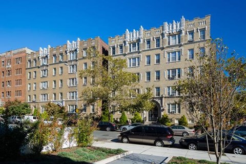 a large apartment building with cars parked in front of it