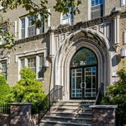 the front of a building with a door and stairs