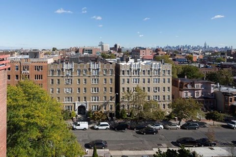 a view of a building with cars parked in a parking lot