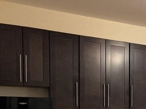 a kitchen with black appliances and wooden floors