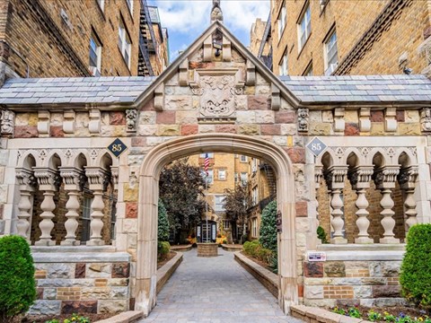 an archway between two buildings in a courtyard