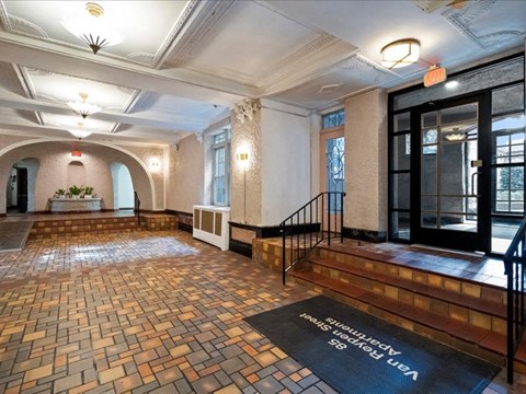 the lobby of a building with stairs and a rug on the floor
