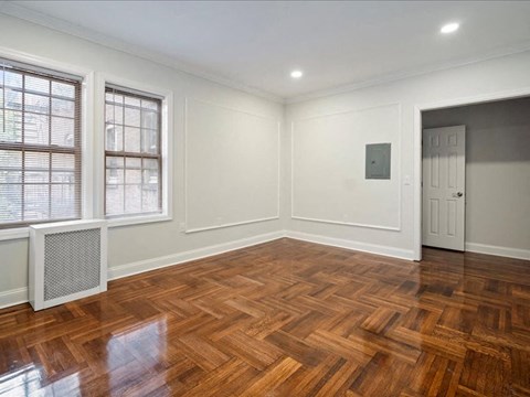 a living room with a hard wood floor and a door
