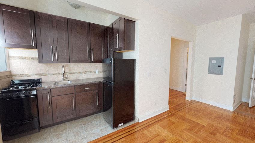 a kitchen with wooden cabinets and a black refrigerator