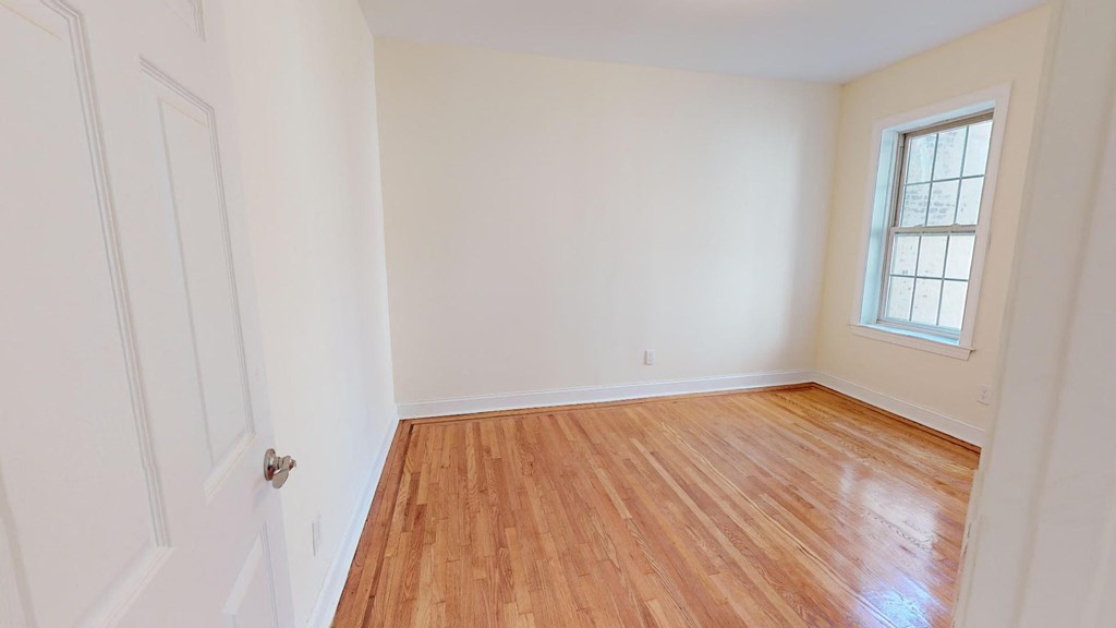 a empty room with a wooden floor and a window