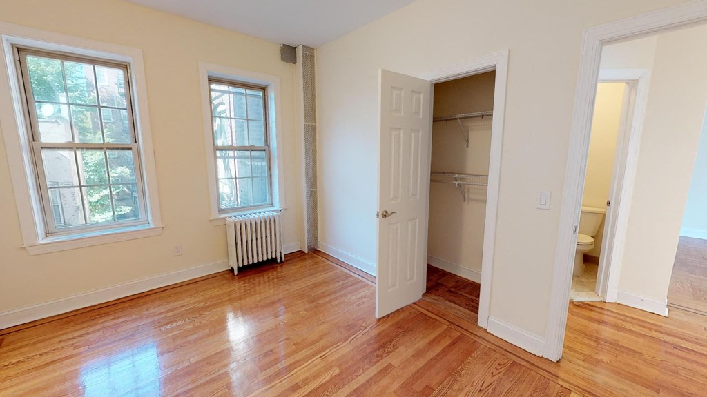 an empty room with a door open to a closet