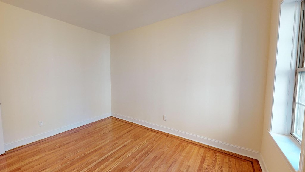 a empty room with a wooden floor and a window