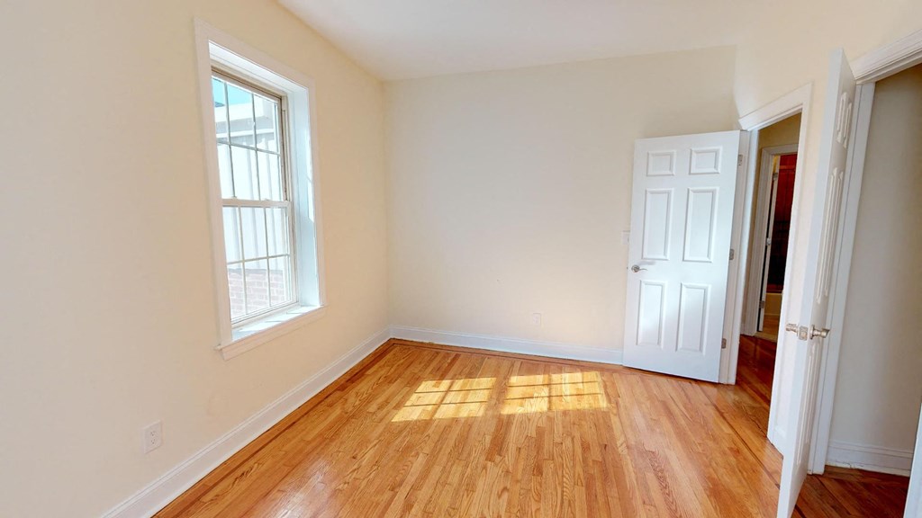 a empty room with a wooden floor and a window