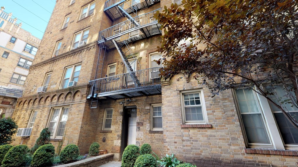 a brick apartment building with two balconies and a door