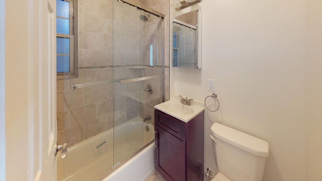 a bathroom with a shower and a toilet and a sink