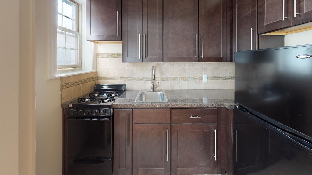a kitchen with black appliances and wooden cabinets
