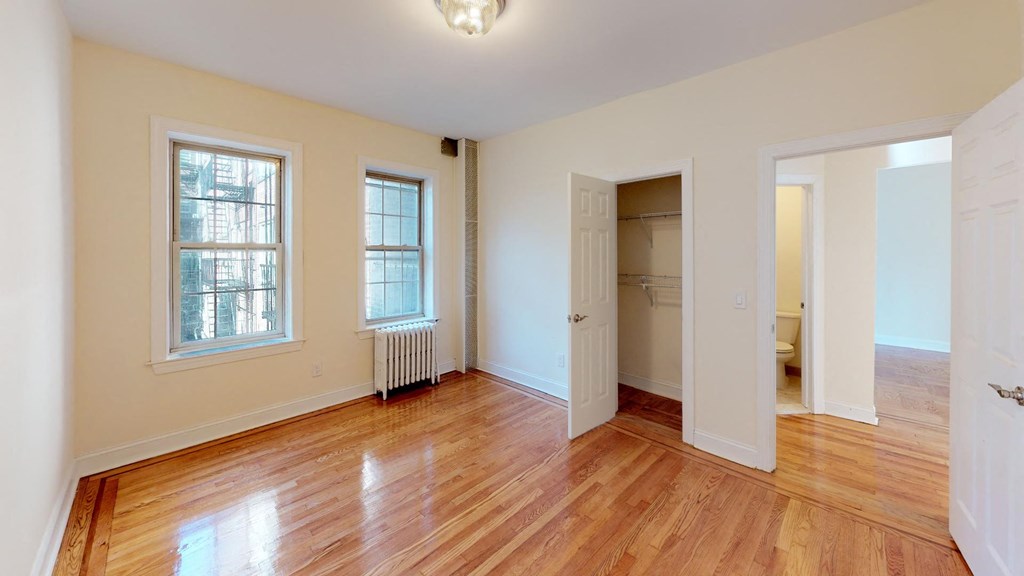 an empty living room with wood floors and a door to a closet