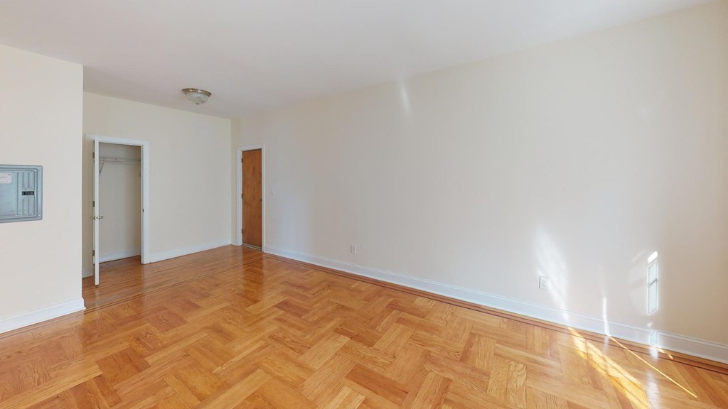 a empty living room with wood flooring and white walls
