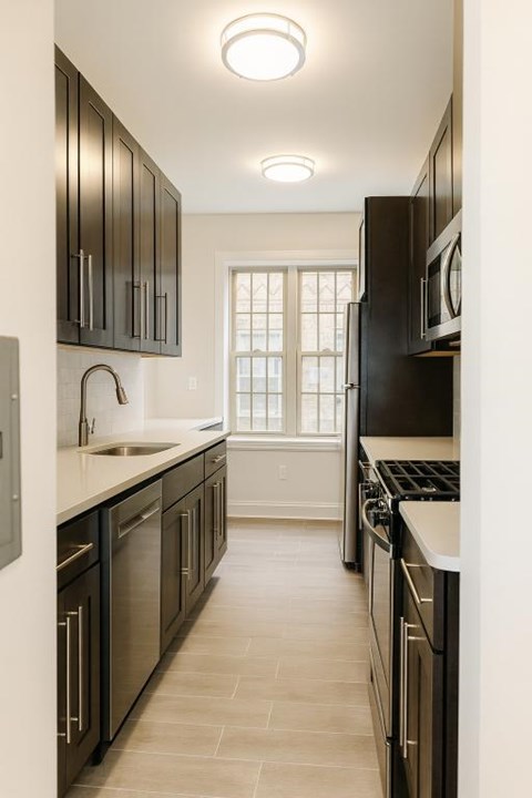 A kitchen with black cabinets and a white counter.
