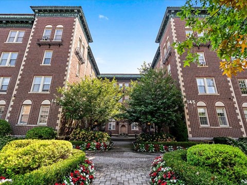 a large brick building with a courtyard in front of it