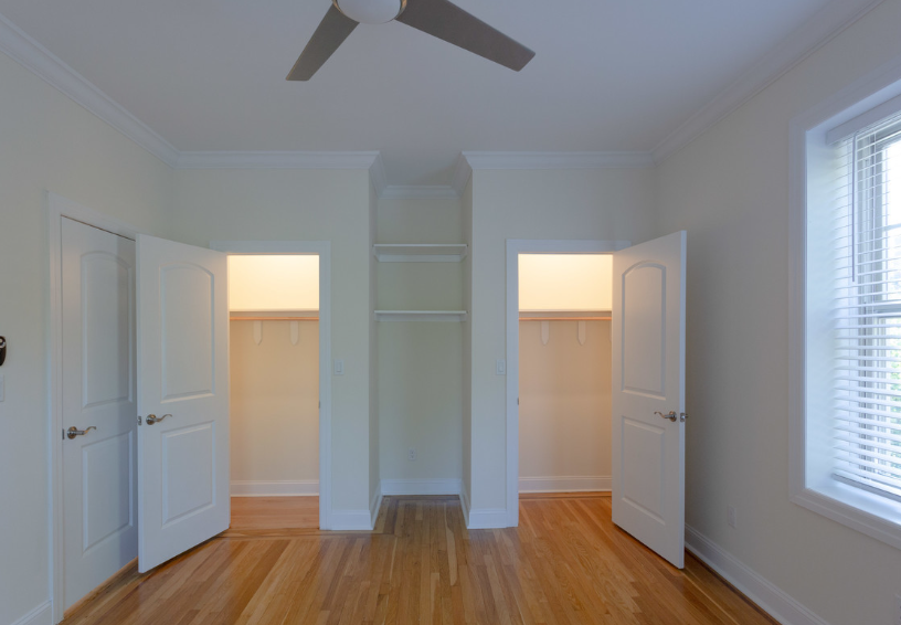 an empty room with three doors and a ceiling fan