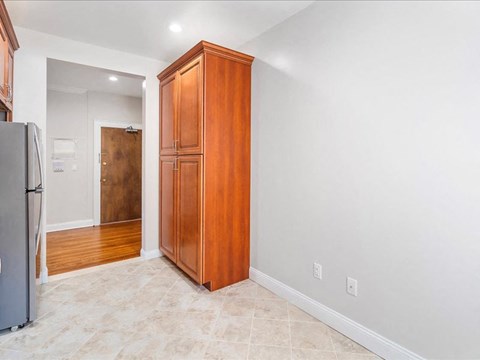 a kitchen with a wooden cabinet and a refrigerator