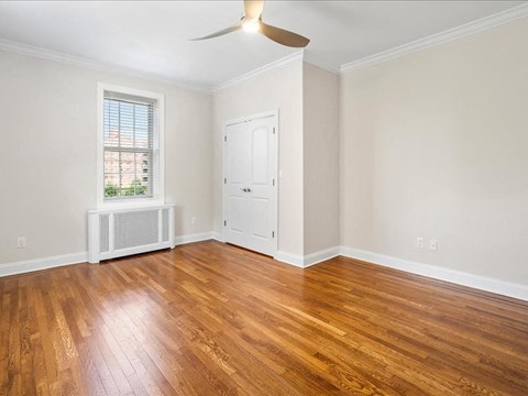 an empty living room with wood floors and a white door