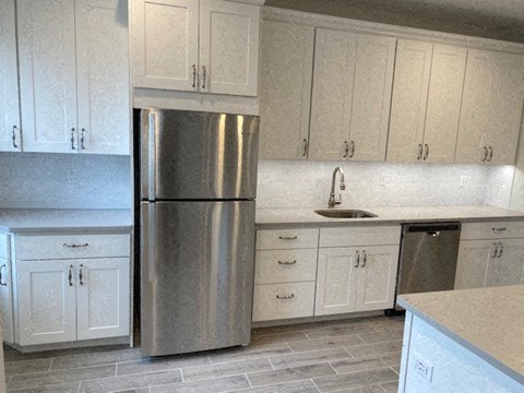 a kitchen with white cabinets and a stainless steel refrigerator