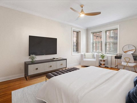 the bedroom has a large bed and a tv on the wall