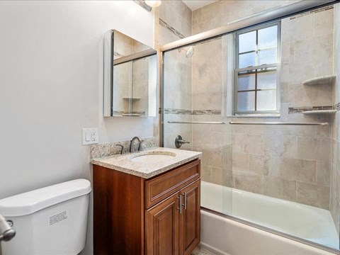 a bathroom with a toilet and a sink and a shower