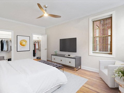 the bedroom has a large bed and a tv on the wall