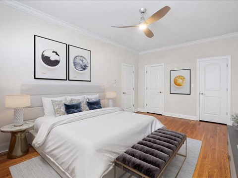 a bedroom with a white bed and a ceiling fan