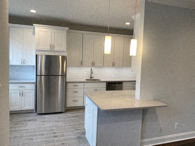 a kitchen with white cabinets and a stainless steel refrigerator