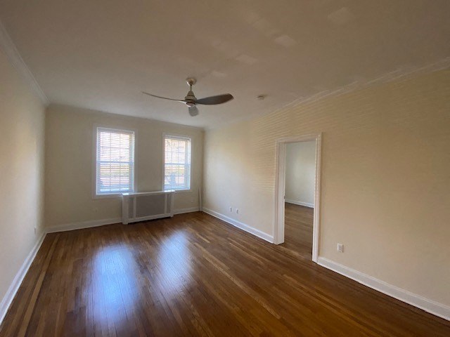 an empty living room with a ceiling fan