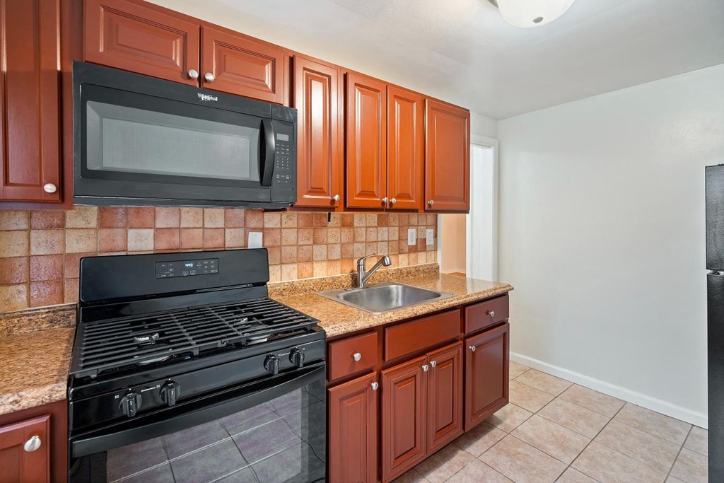 a kitchen with a stove microwave and sink