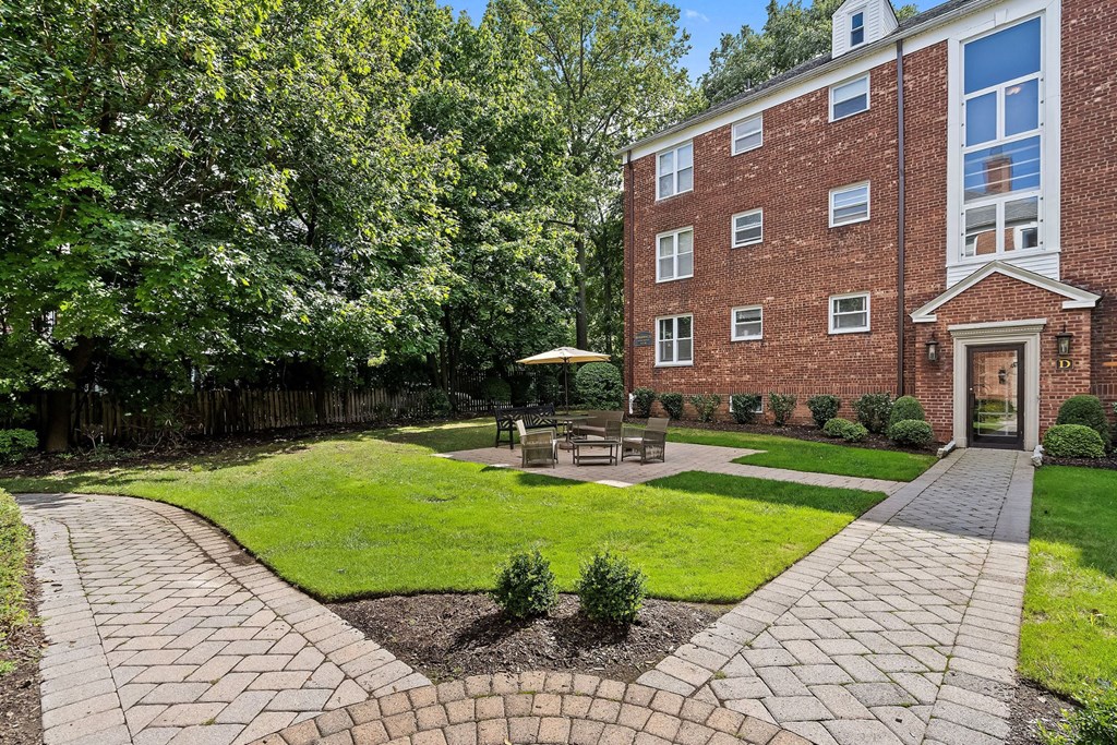 a brick building with a courtyard with grass and trees