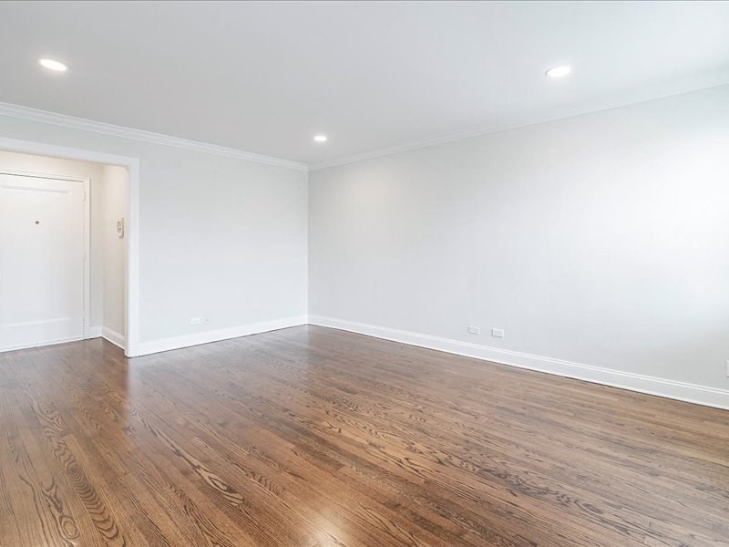 A room with wooden flooring and a white door.